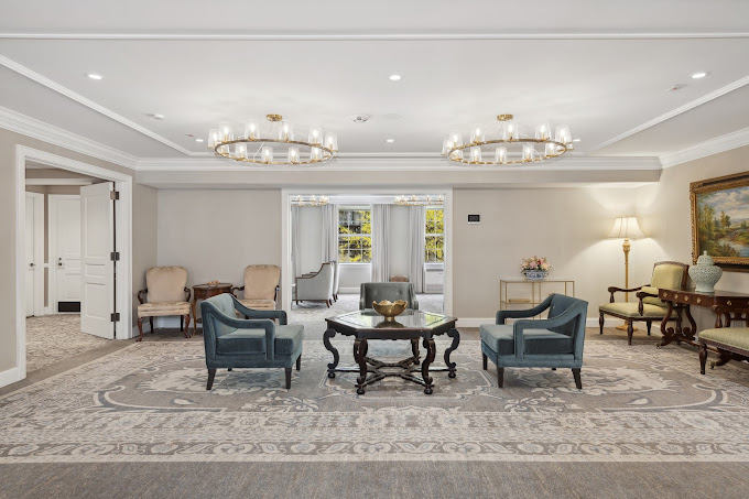 An interior view of a guest waiting area at Frank E. Campbell Funeral Chapel.  Luxury abounds in every detail including the chairs, furniture, area rugs and lighting.