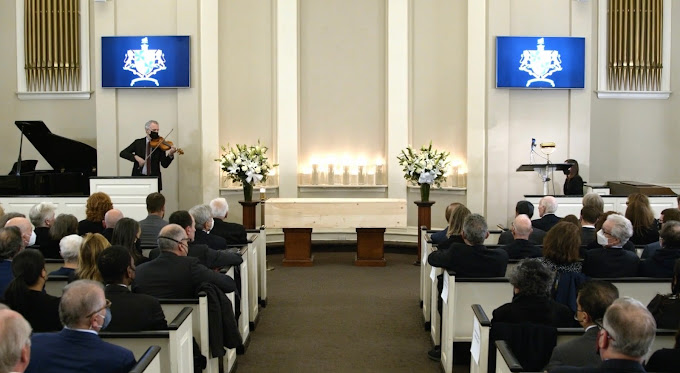 A funeral service being held at Frank E. Campbell Funeral Chapel.  A violin and piano are played at the memorial.